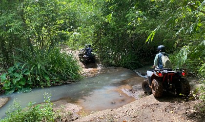 Someone crossing a river on their quad bike