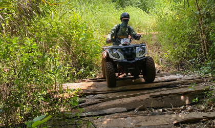 Person riding their quad bike in wood trail